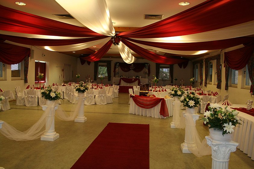 Gemeindehalle: bestuhlt und festlich in weiß-rot eingedeckt und dekoriert (Abendbeleuchtung)